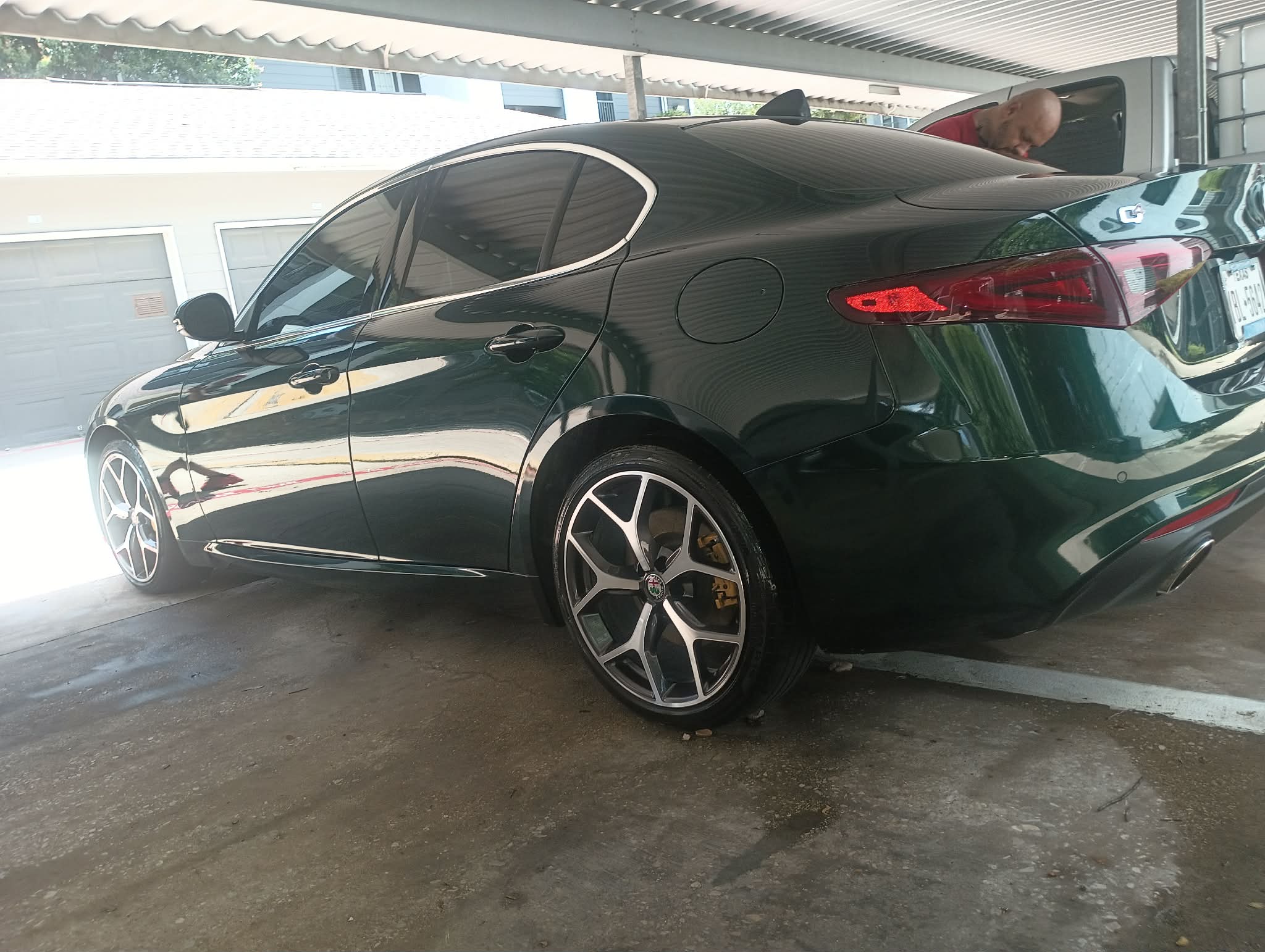Finished glossy black detailed car parked in a carport