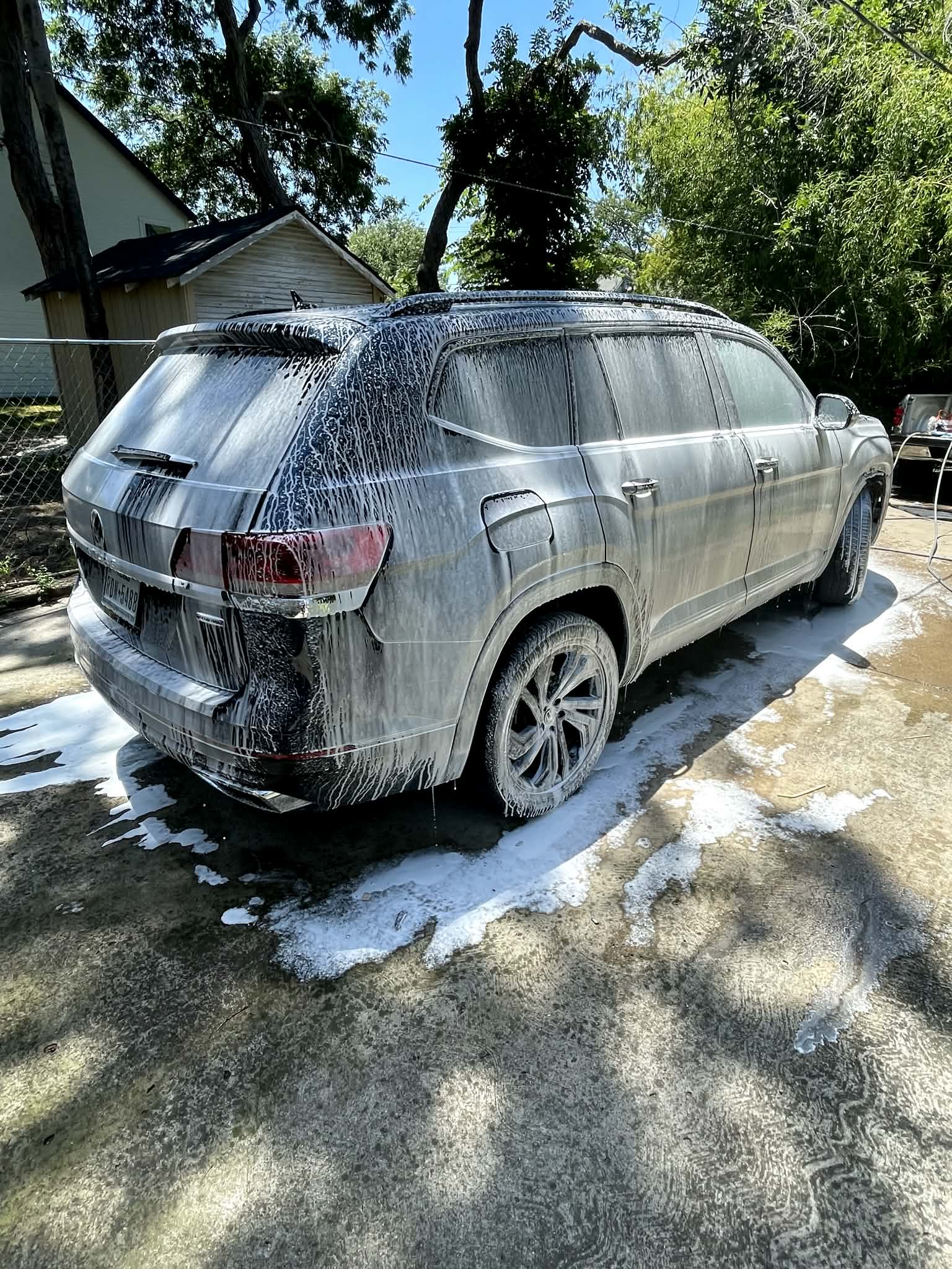 Foam-covered SUV rear during the hand wash and rinse stage