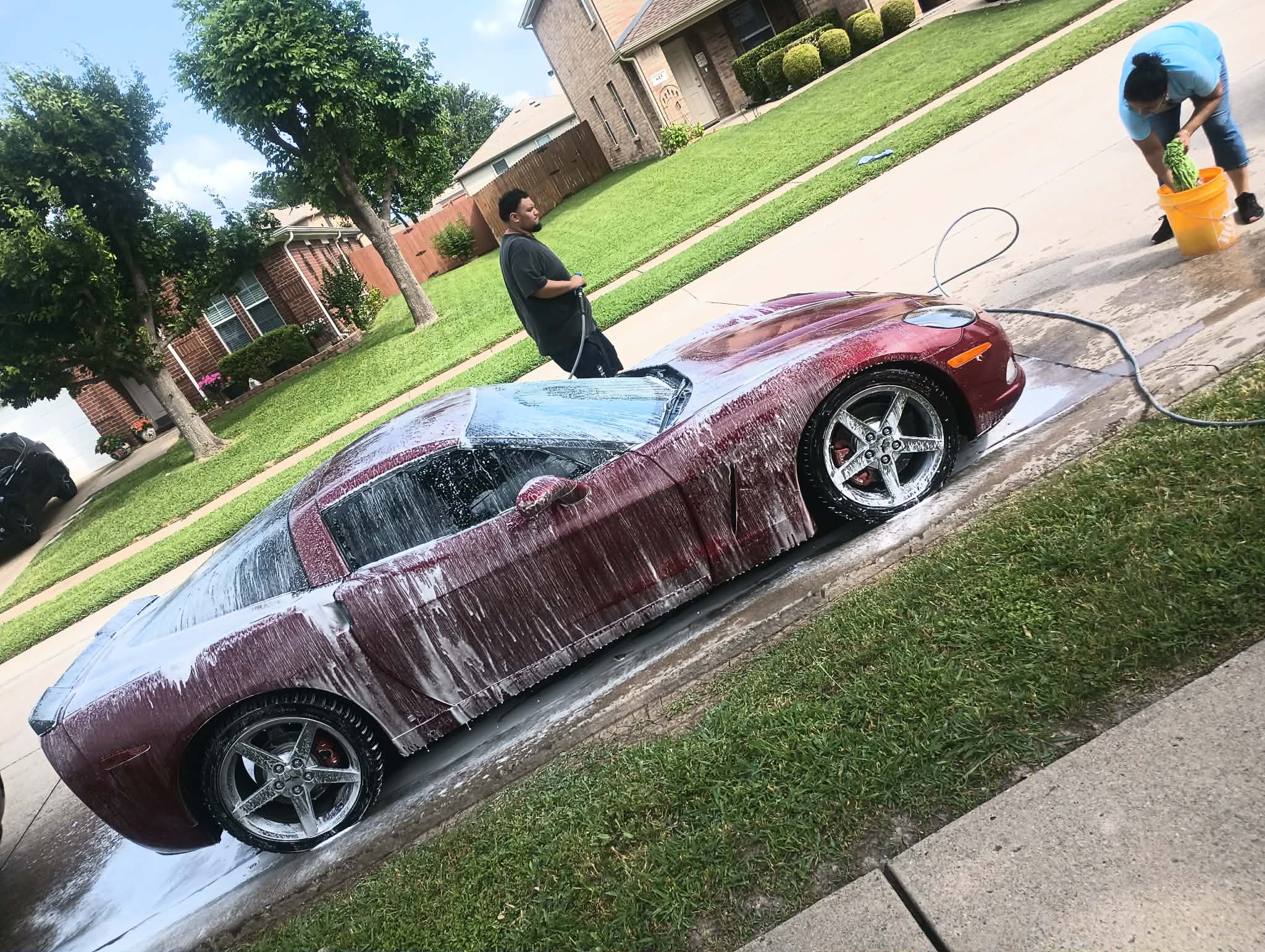 Foam pre-soak covering a Chevrolet Corvette before hand wash